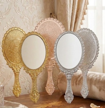 vintage handheld mirror with embossed flower design